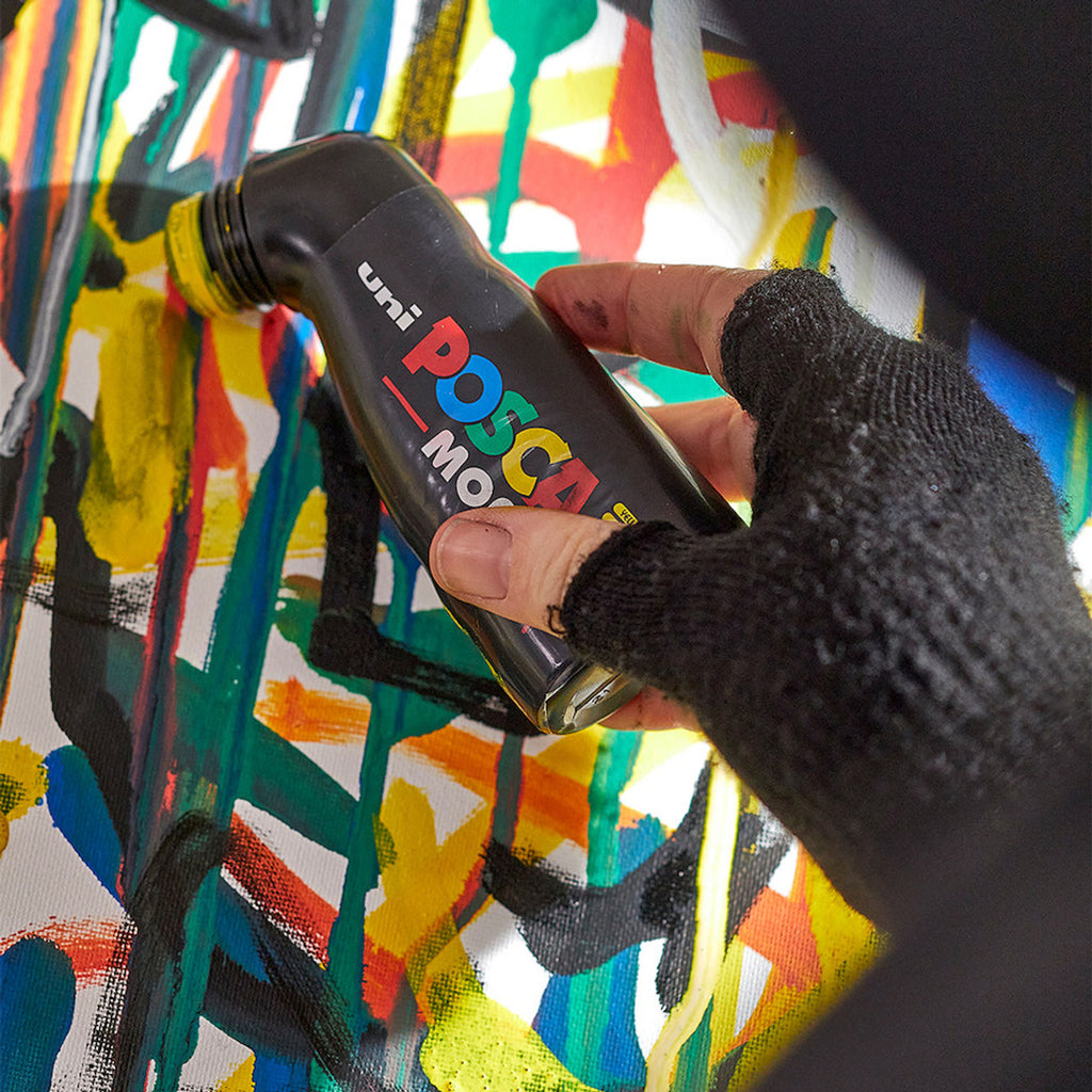 Artist using a POSCA PCM22 MOP’r paint marker on a wall image